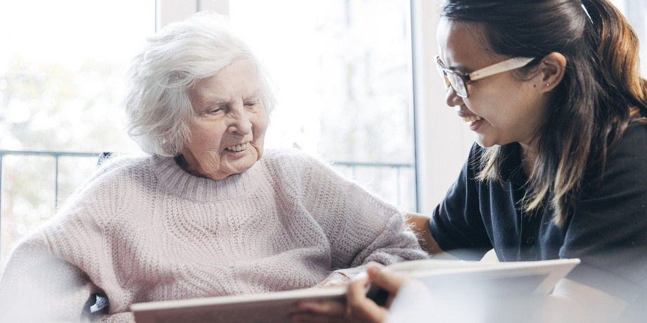 Pflegerin liest Bewohnerin vor